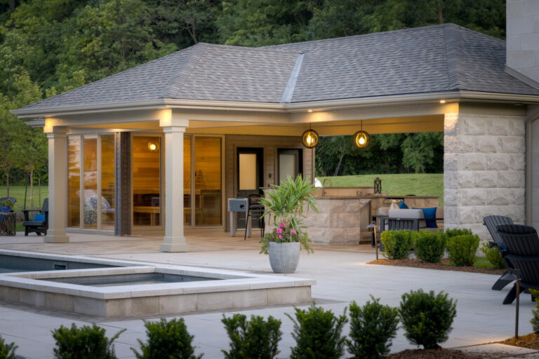 A modern outdoor patio features a pavilion, seating area, and pool surrounded by greenery and trees, creating a cozy, natural atmosphere.